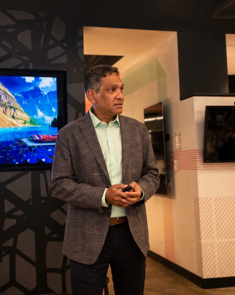 Srini Koushik speaking in a working room